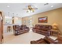 Spacious living room features tile floors and leather couches open to dining area at 21280 N 262Nd Dr, Buckeye, AZ 85396