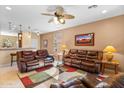 Spacious living room with leather furniture and ceiling fan at 21280 N 262Nd Dr, Buckeye, AZ 85396