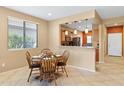 Charming dining area with a warm color palette, a breakfast bar, and natural light perfect for casual meals at 26171 W Via Del Sol Dr, Buckeye, AZ 85396