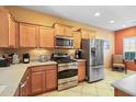 Modern kitchen with stainless steel appliances and wood cabinets at 26171 W Via Del Sol Dr, Buckeye, AZ 85396