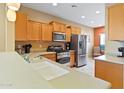 Well-lit kitchen with stainless steel appliances, wood cabinets, and an expansive countertop at 26171 W Via Del Sol Dr, Buckeye, AZ 85396