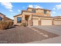 Two-story house with beige exterior, stone accents, and a two-car garage at 46108 W Tulip Ln, Maricopa, AZ 85139