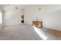 Bright living room with neutral carpeting, a wooden cabinet, and vaulted ceilings at 46108 W Tulip Ln, Maricopa, AZ 85139