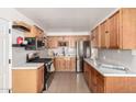 Modern kitchen with light wood cabinets, stainless steel appliances, and quartz countertops at 5031 W Flynn Ln, Glendale, AZ 85301