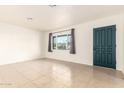 Empty living room with tile floors and a view of the street at 5031 W Flynn Ln, Glendale, AZ 85301