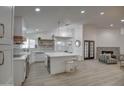 Modern kitchen featuring white cabinets, quartz countertops, and a large island at 6017 E Beck Ln, Scottsdale, AZ 85254