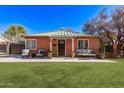 Charming brick home with a cozy front porch seating area and green lawn at 6811 N 11Th Ave, Phoenix, AZ 85013