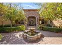 Stately stone facade frames the main entrance and water feature of this luxury home at 6876 S Star Dr, Gilbert, AZ 85298