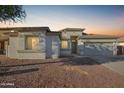 House exterior at dusk, showcasing a neutral color scheme and landscaping at 6924 W Southgate Ave, Phoenix, AZ 85043