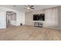 Spacious living room featuring wood-look tile flooring and a large TV at 6924 W Southgate Ave, Phoenix, AZ 85043