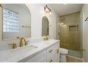 Elegant bathroom featuring double sinks, gold fixtures, and a walk-in shower at 7432 E Latham St, Scottsdale, AZ 85257