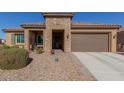 House exterior featuring a two-car garage and covered entryway at 8202 W Merriweather Way, Florence, AZ 85132