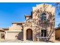 Two-story house with Spanish-style architecture, featuring a large garage and landscaped front yard at 10116 W Luxton Ln, Tolleson, AZ 85353