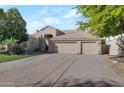 Tan two-story house with three-car garage and landscaped front yard at 12056 E Bella Vista Cir, Scottsdale, AZ 85259