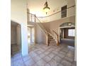 Grand two-story entryway with curved staircase and tile flooring at 12419 W Monte Vista Rd, Avondale, AZ 85392