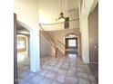 Two-story entryway, curved staircase, tile floors, and views to other rooms at 12419 W Monte Vista Rd, Avondale, AZ 85392