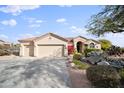 Two-car garage and desert landscaping with a tan colored house at 15020 E Sierra Madre Dr, Fountain Hills, AZ 85268