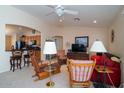 Living room with open floor plan, showcasing a view of the kitchen and a large TV at 16549 W Desert Ln, Surprise, AZ 85388