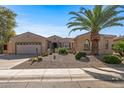 Single-story home with desert landscaping and a two-car garage at 16935 W Villagio Dr, Surprise, AZ 85387