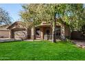 House with attractive landscaping and a large tree in the front yard at 20838 N 101St Dr, Peoria, AZ 85382