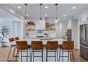 Modern kitchen with white cabinets, large island, and stainless steel appliances at 22085 E Rosa Rd, Queen Creek, AZ 85142