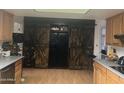 Kitchen features dark wood barn doors and black appliances at 4038 W Morrow Dr, Glendale, AZ 85308