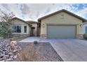 Tan house with a gray garage door and stone accents at 4347 W White Horse Blvd, Eloy, AZ 85131