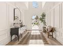 Bright foyer with paneled walls, skylight, light wood floors, and a view through the glass door at 5314 E Calle Del Norte --, Phoenix, AZ 85018