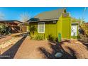 Green bungalow with a covered patio and walkway, showcasing a charming curb appeal at 59 N Adams St, Wickenburg, AZ 85390