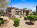 Charming single-story home with desert landscaping, a tile roof, stone accents, and an attached two-car garage at 6202 E Mckellips Rd # 83, Mesa, AZ 85215