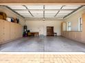 Spacious garage with ample cabinet storage, a large open area, and an access door to the main home at 6202 E Mckellips Rd # 83, Mesa, AZ 85215