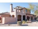 Elegant two-story home with a stone fireplace and covered patio at 7701 E Golden Eagle E Cir, Gold Canyon, AZ 85118