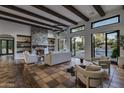 Spacious living room with a stone fireplace and large windows overlooking the pool at 8408 E La Senda Dr, Scottsdale, AZ 85255