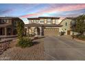 Two-story house with a large driveway, basketball hoop, and landscaped front yard at dusk at 904 E Zesta Ln, Gilbert, AZ 85297