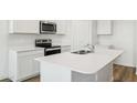 Modern kitchen island with white cabinets and stainless steel appliances at 18363 W Smoketree Dr, Wittmann, AZ 85361