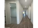 Bright hallway featuring hardwood floors and neutral paint, leading to the bedroom at 22852 E Lords Way, Queen Creek, AZ 85142