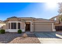 Tan house with tile roof, two-car garage, and desert landscaping at 25583 W Beth Dr, Buckeye, AZ 85326