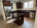 Spacious kitchen with dark wood cabinets, granite counters, and island at 3480 E Sheffield Rd, Gilbert, AZ 85296