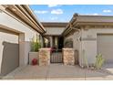 Front entry with a gated courtyard and stone accents at 41711 N Maidstone Ct, Anthem, AZ 85086