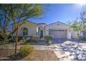 Single story home with neutral exterior, two-car garage, and landscaped front yard at 5015 S Quantum Way, Mesa, AZ 85212