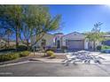 Single story home with neutral exterior, two-car garage, and landscaped front yard at 5015 S Quantum Way, Mesa, AZ 85212