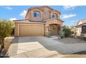 Two-story house with tan exterior, landscaped yard, and a two-car garage at 5415 W Pontiac Dr, Glendale, AZ 85308