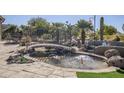 Landscaped backyard featuring a pond with bridge and fountain at 5500 N Globe Dr, Eloy, AZ 85131