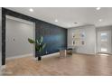 Bright dining room with glass table, wood floors, and patterned wall at 744 E Desert Ln, Phoenix, AZ 85042