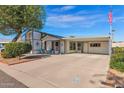 House with carport, mature tree, and American flag at 8500 E Southern Ave # 126, Mesa, AZ 85209