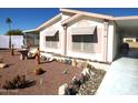 Landscaped manufactured home with decorative rock and a carport at 106 S 72Nd Way, Mesa, AZ 85208