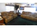 Spacious living room with two brown sofas and green carpet at 106 S 72Nd Way, Mesa, AZ 85208