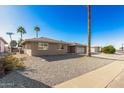 Single story home with gravel yard and palm trees at 11009 W Crestbrook Dr, Sun City, AZ 85351