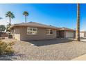 Single-story home with a two-car garage and desert landscaping at 11009 W Crestbrook Dr, Sun City, AZ 85351