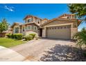 Two-story house with stone accents and a paved driveway at 13713 W Harvest Ave, Litchfield Park, AZ 85340